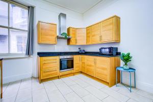迪拜Dubai Media City Convenient Apartments的一间带木制橱柜和微波炉的厨房