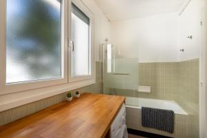 古雷特Lou Moussu的一间带水槽和浴缸的浴室以及窗户。
