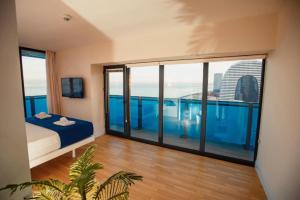 巴统ORBI CITY Beautiful Luxurios Panoramic View on batumi的客房设有床和大型玻璃窗。