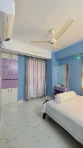 达卡Baridhara Sweet Home的一间卧室设有一张床和蓝色的墙壁