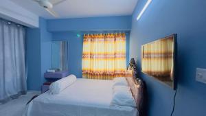 达卡Baridhara Sweet Home的蓝色的卧室设有床和窗户