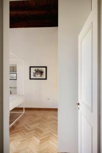 那不勒斯Posillipo 70 Napoli的通向白色墙壁和木地板的客房的开放式门