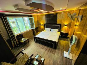 TandalPOLO LAND HOTEL Skardu的一间卧室配有一张床和一张带风扇的书桌