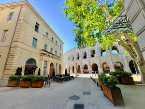 尼姆Nî'douillet-P3 Terrasse et climatisé-coeur de ville的一座庭院,位于一座配有桌子和长凳的建筑中