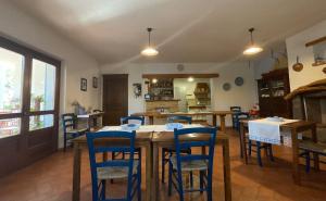 多尔加利Residenza di Campagna Dolmen Motorra的用餐室配有木桌和蓝色椅子