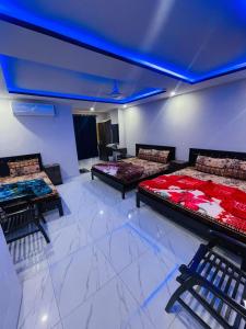 伊斯兰堡Moven Inn Hotel Islamabad的客房设有三张床和蓝色天花板。