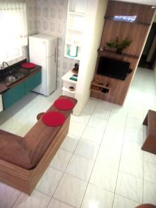 圣安东尼奥-杜皮尼亚尔Cantinho Aconchego的一间铺有白色地板并配有红色柜台的厨房