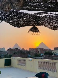 开罗Four pyramids Guest house pyramids View的从建筑物屋顶上可欣赏到金字塔的景色