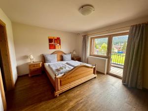 洛伊塔施汉德尔公寓酒店的一间卧室设有一张床和一个大窗户