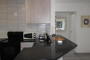 马盖特Laguna La Crete 4的厨房配有黑色台面和微波炉