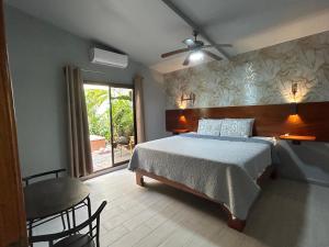 福尔图纳Iki Volcán Arenal的一间卧室配有一张床、一张桌子和一个窗户。