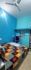 AyodhyaKishori ram guest house 5 minute walking distance from railway station的一间设有床铺的卧室,位于一间拥有蓝色墙壁的房间