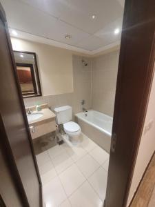 阿卜杜勒国王经济城Lotus Apartments的浴室配有卫生间、浴缸和水槽。