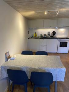 费尔耶斯塔登Idyliska boende mitt på Öland的一间厨房,内设一张桌子和蓝色的椅子