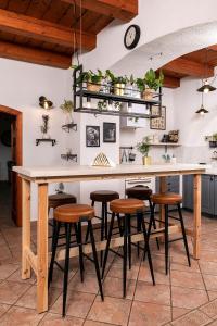 BalatonszőlősGella Kúria的厨房配有带凳子和桌子的柜台