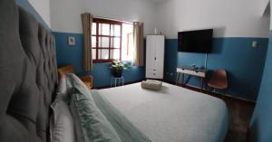 利马Miraflores Kennedy Park的一间卧室配有一张蓝色墙壁的床和一扇窗户