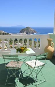 伊斯基亚Villa Eleonora, un angolo di Paradiso ad Ischia的阳台配有一张桌子和两把椅子,享有海景