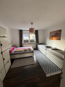 奥伯豪森Sana Ferienwohnung的小房间设有两张床和窗户