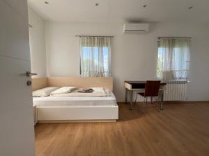 伊利扎Villa Amela的白色卧室配有床和书桌