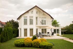 伊利扎Villa Amela的白色的房子,配有桌子和雨伞