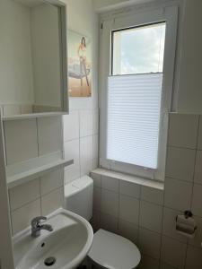 Monteur-Pension N2的一间带水槽和卫生间的浴室以及窗户。