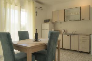 卡什泰拉Apartment Gloria的带木桌和椅子的厨房以及带柜台的厨房。