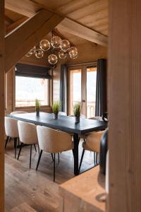 梅杰夫Luxury Megève Chalet, sleeps 8 with Mountain Views and Jacuzzi的一间带桌椅和吊灯的用餐室