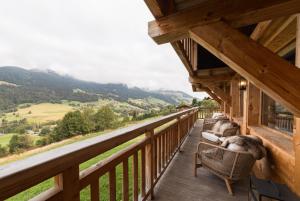 梅杰夫Luxury Megève Chalet, sleeps 8 with Mountain Views and Jacuzzi的山景阳台(带椅子)