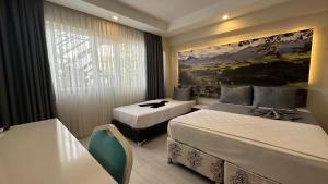 安塔利亚Antalya Dream Hotel的酒店客房设有两张床,墙上挂有绘画作品
