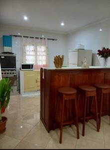 圣多美VIP Guest House Campo de Milho的厨房配有木台和凳子