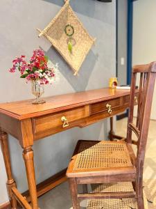 布希奥斯Villa Lulu Geribá的一张带花瓶和椅子的木桌