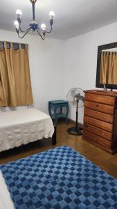 波萨达斯Casa céntrica muy comoda的一间卧室配有床、梳妆台和蓝色地毯。