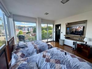 昆卡Maravilloso departamento con moto electricá的一间卧室配有一张床和一台平面电视