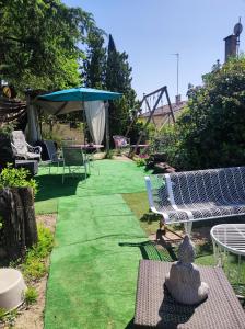 尼姆Ingrid Mary的花园设有椅子和遮阳伞及草地