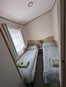 塞顿港Abi static caravan close to Edinburgh的小房间设有两张床和窗户