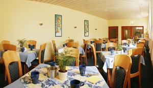 斯图加特潘森克那申酒店的用餐室配有桌椅和植物