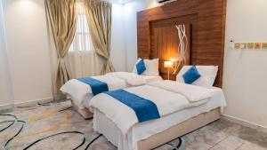 哈伊勒فندق زائر الشمال的蓝色和白色的酒店客房内的两张床