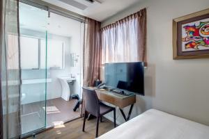 悉尼57号酒店的酒店客房设有一张书桌、一台电视和一间浴室。