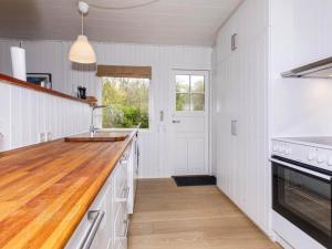 NibeHoliday home Nibe VI的厨房配有白色橱柜和木制台面