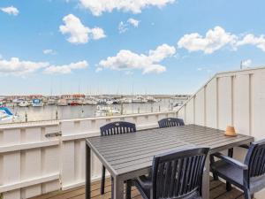 Nibe4 person holiday home in Nibe的阳台享有海港景致,配有桌椅。