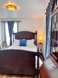 帕尔默Werner Room 204, Hyland Hotel的一间卧室配有一张带蓝色窗帘的木床
