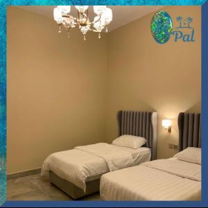欧普尔Opal Resorts的客房设有两张床和吊灯。