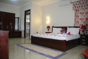 库马西Gold Plus Hotel Ghana的一间卧室配有一张大床,装饰有装饰