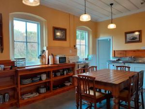 WaipiataPeter's Farm Lodge的一间带木桌的厨房和一间餐厅