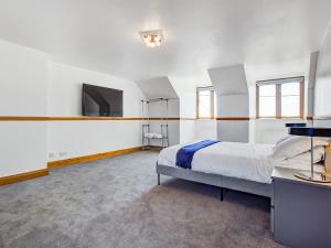 Isle of SheppeyTotal Retreat的一间卧室配有一张床和一台平面电视