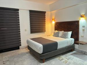 巴亚尔塔港Ixaya的一间卧室配有一张带黑色百叶窗的大床