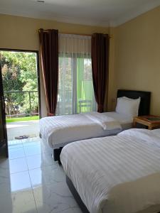 不拉士打宜Kaesa Homestay的酒店客房设有两张床和窗户。