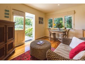 欧尼罗亚Romantic Cottage Recommended by NZ Herald的客厅配有沙发和桌子