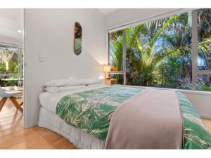 欧尼坦基Bellbird Paradise- Waiheke Escapes的一间卧室设有一张床和一个大窗户
