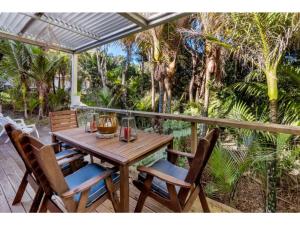 欧尼坦基Bellbird Paradise- Waiheke Escapes的树廊上的木桌和椅子